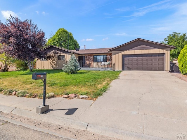 213 Starlite Dr, Pueblo, CO 81005 - single story home with a front lawn, concrete driveway, an attached garage, and board and batten siding