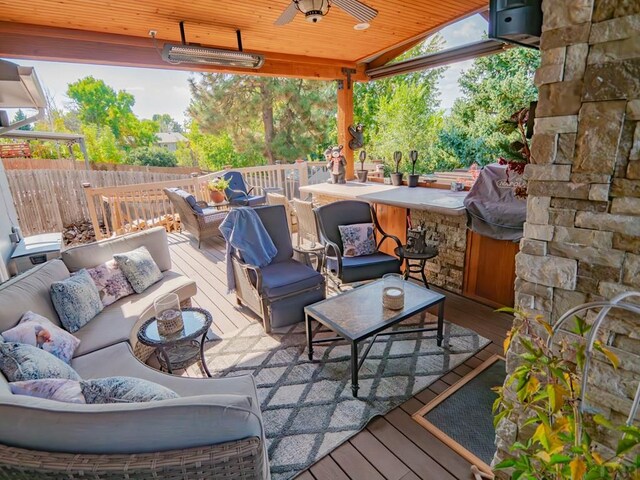 view of patio featuring a ceiling fan, outdoor lounge area, fence, and a deck