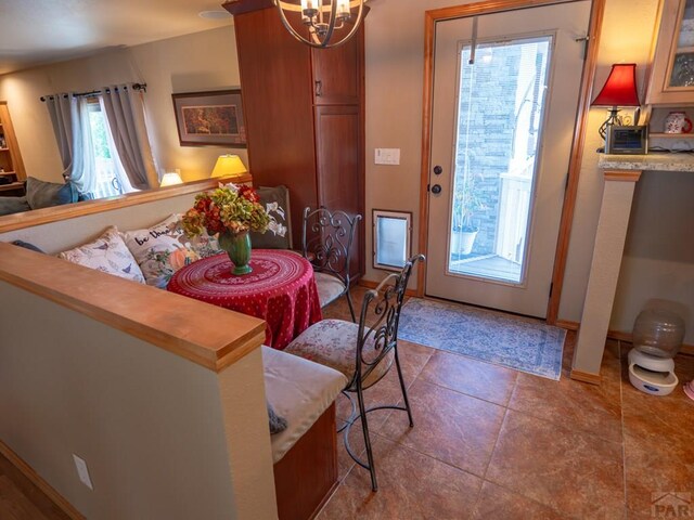 tiled dining room featuring baseboards and a chandelier