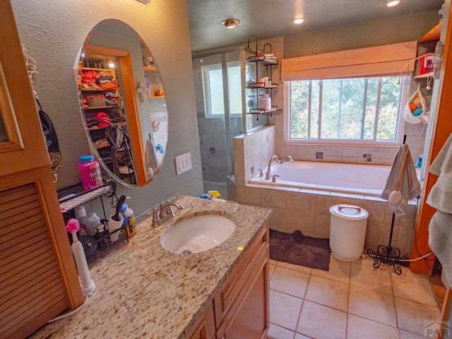 full bathroom featuring tile patterned flooring, vanity, a spacious closet, a shower stall, and a bath