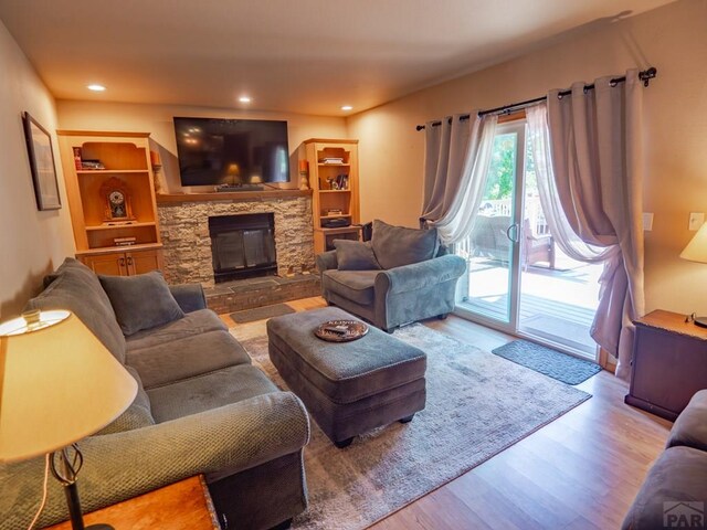 living area with a fireplace, wood finished floors, and recessed lighting