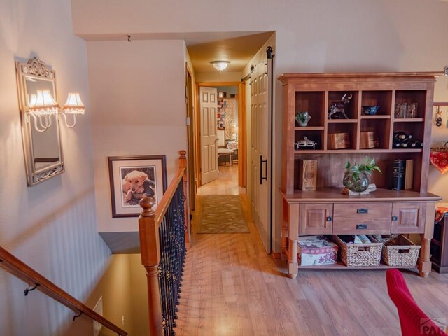 hall featuring a barn door and light wood-type flooring