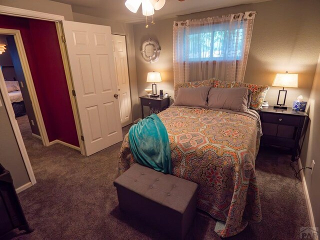 bedroom with dark carpet and baseboards