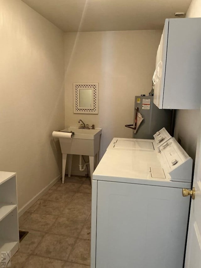 laundry area featuring baseboards, laundry area, a sink, and washer and dryer