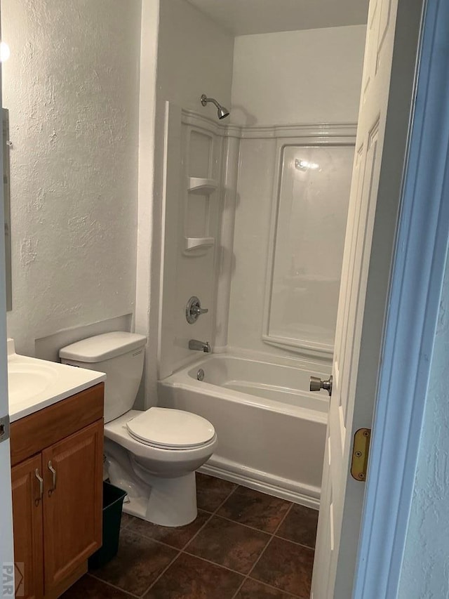 full bathroom featuring a textured wall, toilet, washtub / shower combination, vanity, and tile patterned floors