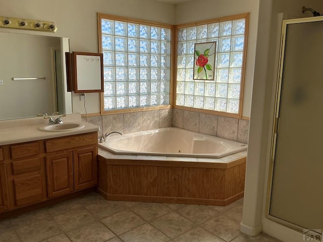 bathroom featuring a whirlpool tub, tile patterned floors, a shower stall, and vanity