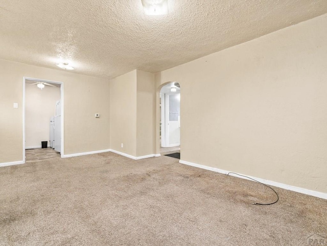1908 Claremont Ave, Pueblo, CO 81004 - carpeted empty room with arched walkways, a textured ceiling, and baseboards