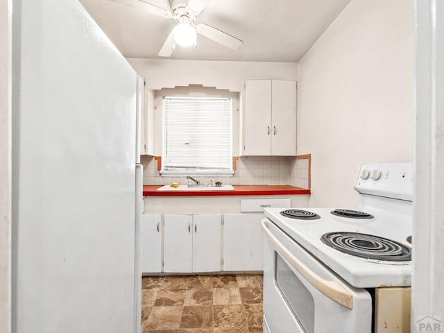 1908 Claremont Ave, Pueblo, CO 81004 - kitchen featuring white appliances, a sink, backsplash, white cabinets, and a ceiling fan