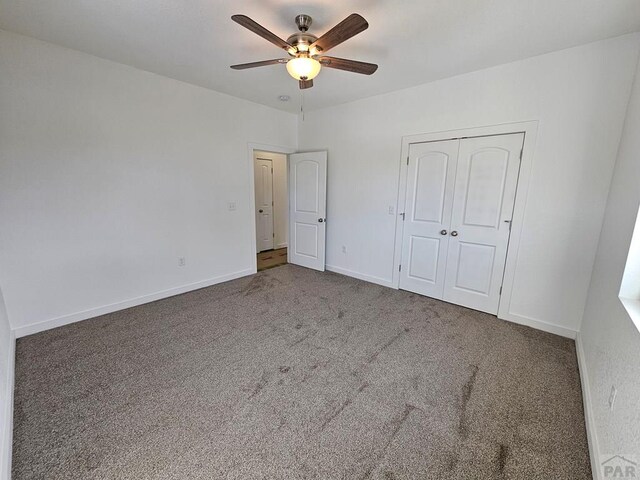 unfurnished bedroom featuring ceiling fan, carpet floors, a closet, and baseboards