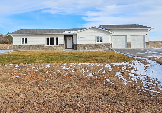 view of front facade featuring concrete driveway, stone siding, a front lawn, and an attached garage