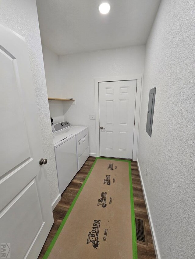 laundry area featuring washing machine and dryer, laundry area, dark wood-style flooring, visible vents, and electric panel