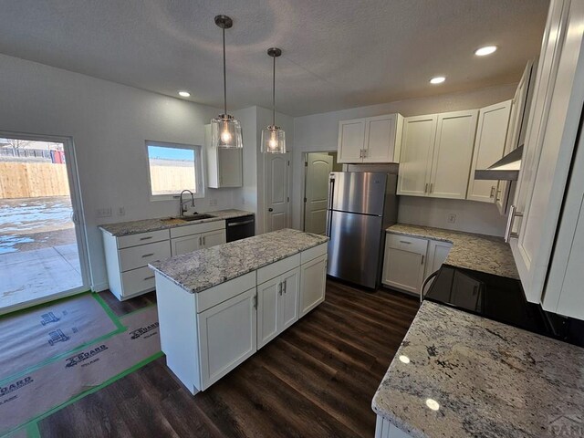 kitchen featuring black dishwasher, white cabinetry, a sink, and freestanding refrigerator