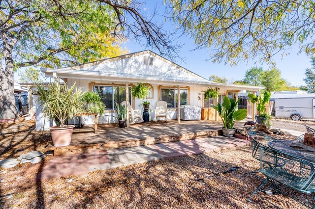 rear view of property featuring a wooden deck and fence