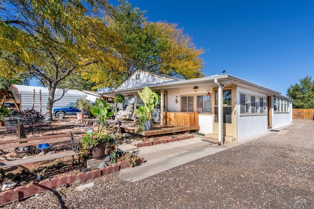 back of property featuring fence and a sunroom