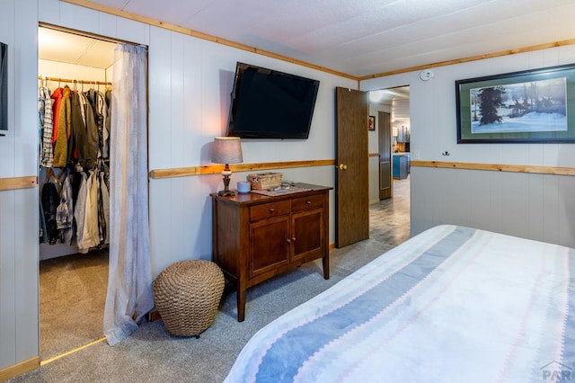 bedroom with a walk in closet, a closet, and light colored carpet