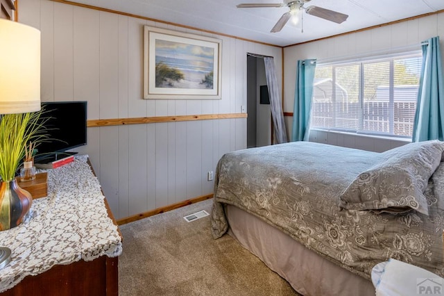 bedroom featuring ceiling fan, ornamental molding, carpet flooring, and visible vents