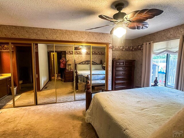 bedroom featuring carpet flooring, ceiling fan, a textured ceiling, and wallpapered walls