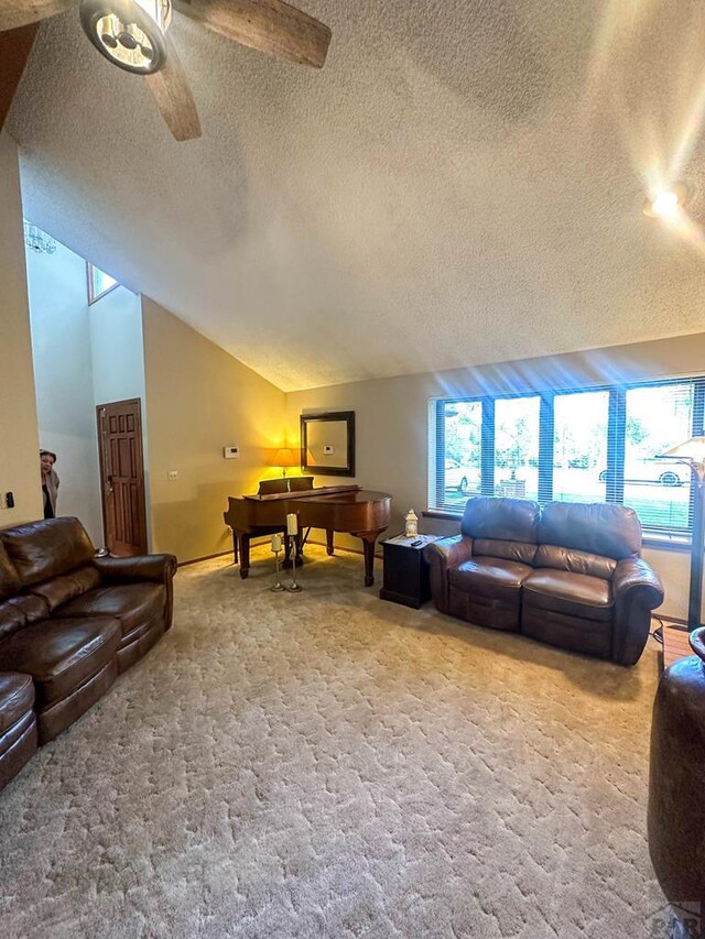 carpeted living area with vaulted ceiling, a textured ceiling, and ceiling fan