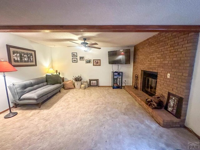 carpeted living area with beam ceiling, a fireplace, and a textured ceiling