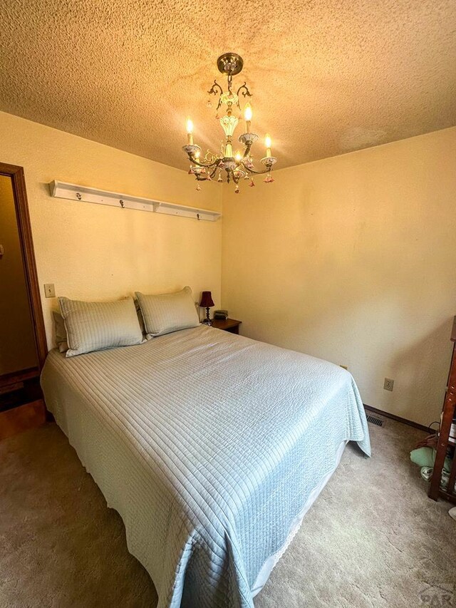 bedroom with an inviting chandelier, carpet, visible vents, and a textured ceiling