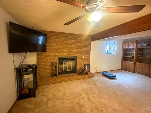 unfurnished living room with carpet floors, a fireplace, a ceiling fan, and a textured ceiling