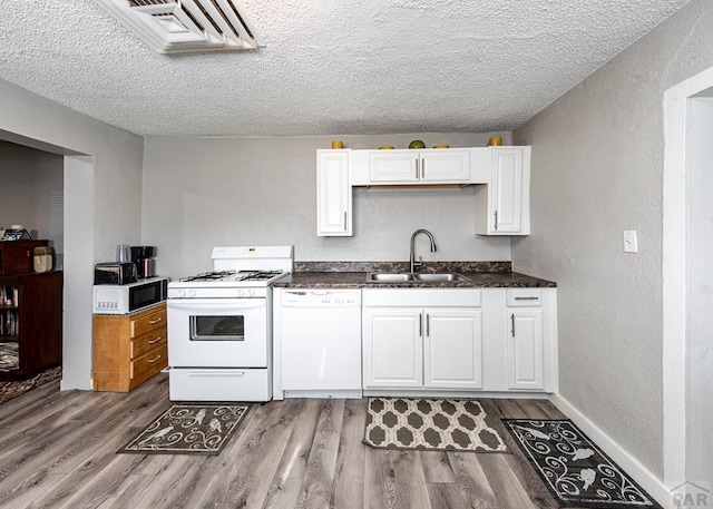 kitchen with white appliances, a sink, and white cabinets