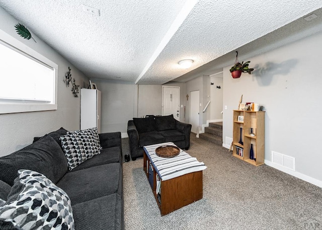 carpeted living area with visible vents, stairway, baseboards, and a textured ceiling