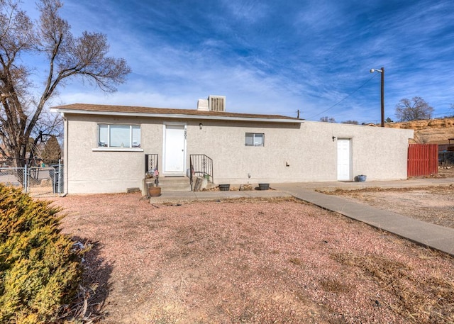 back of house featuring crawl space, fence, and stucco siding