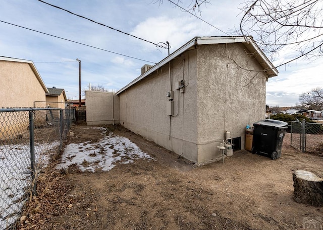 view of home's exterior with fence and stucco siding