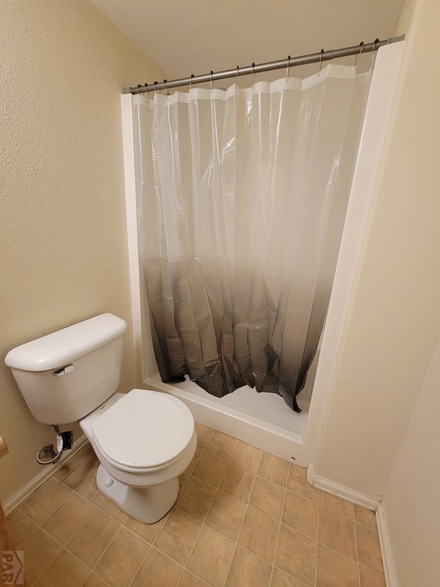 full bathroom featuring toilet, tile patterned flooring, and a shower with shower curtain