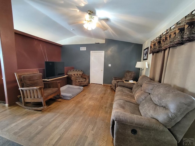 living room featuring vaulted ceiling, visible vents, light wood-style flooring, and a ceiling fan