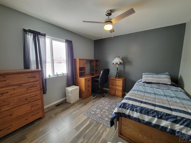 bedroom featuring light wood-type flooring, baseboards, and a ceiling fan