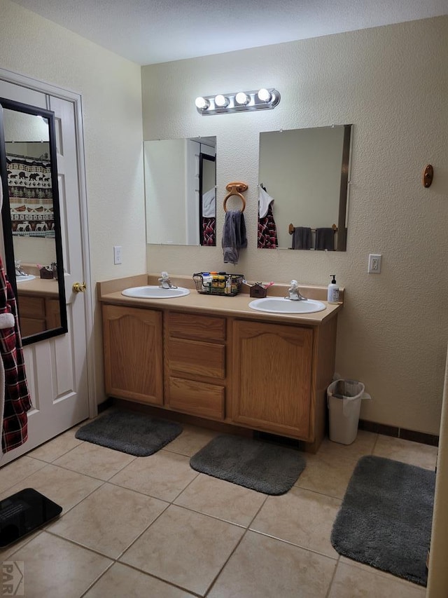 full bathroom featuring double vanity, a sink, and tile patterned floors