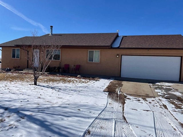 view of front of house with an attached garage, a shingled roof, and stucco siding