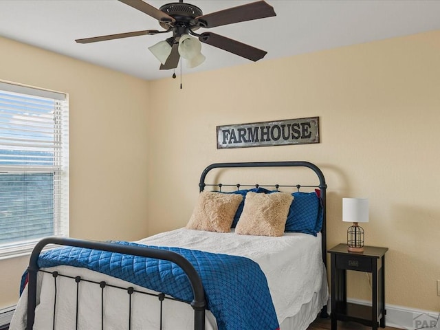 bedroom featuring baseboard heating, ceiling fan, and baseboards