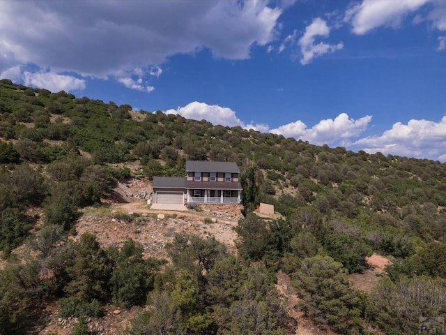 bird's eye view with a wooded view