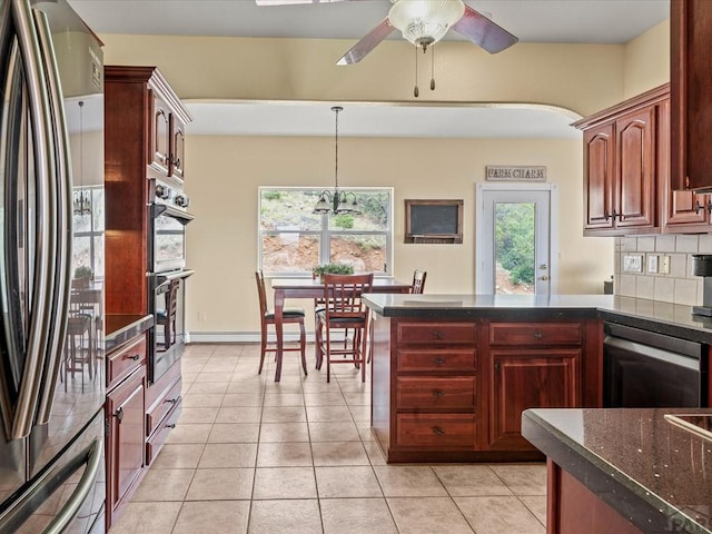 kitchen with light tile patterned floors, a ceiling fan, a peninsula, appliances with stainless steel finishes, and backsplash