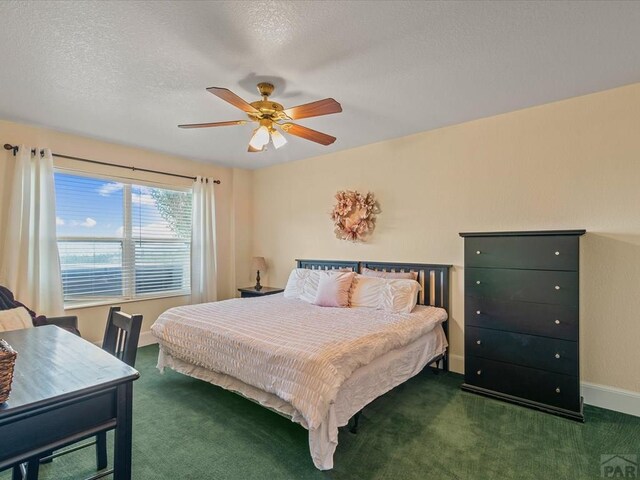 carpeted bedroom featuring a textured ceiling, baseboards, and a ceiling fan