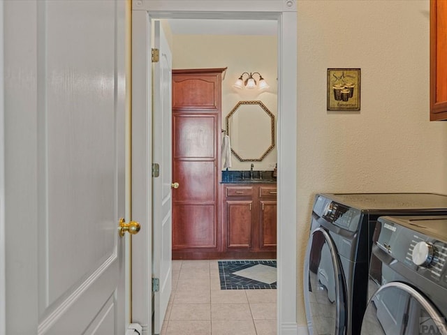 clothes washing area with laundry area, light tile patterned flooring, separate washer and dryer, and a sink