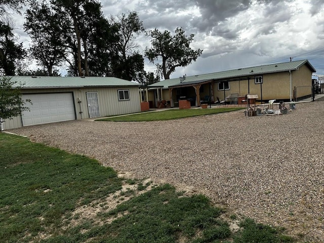 25433 County Rd 25, La Junta, CO 81050 - view of front facade featuring gravel driveway, a garage, metal roof, and a front yard