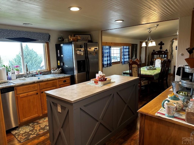 25433 County Rd 25, La Junta, CO 81050 - kitchen featuring stainless steel appliances, a sink, a center island, brown cabinetry, and dark wood-style floors