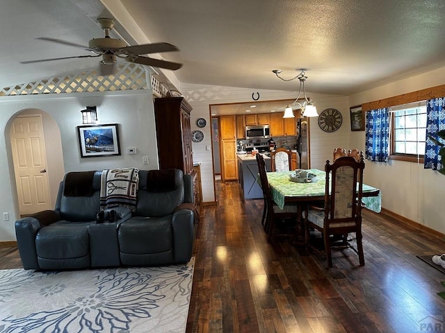 25433 County Rd 25, La Junta, CO 81050 - dining space with dark wood finished floors, ceiling fan, arched walkways, lofted ceiling, and baseboards