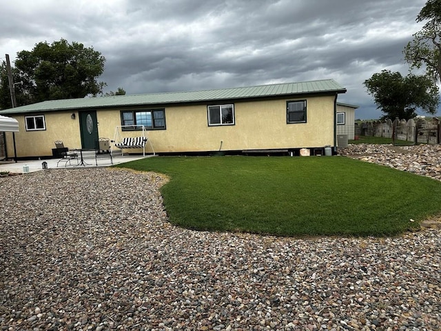 25433 County Rd 25, La Junta, CO 81050 - rear view of property featuring stucco siding, a patio area, metal roof, and a lawn