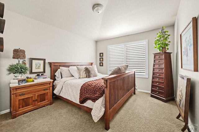 bedroom featuring baseboards, light colored carpet, and lofted ceiling