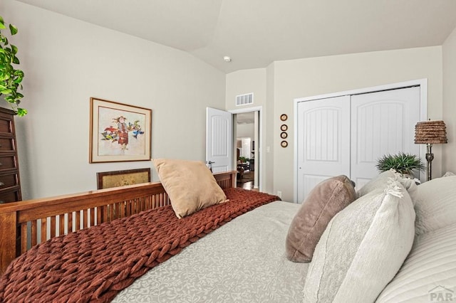 bedroom featuring visible vents, a closet, and lofted ceiling