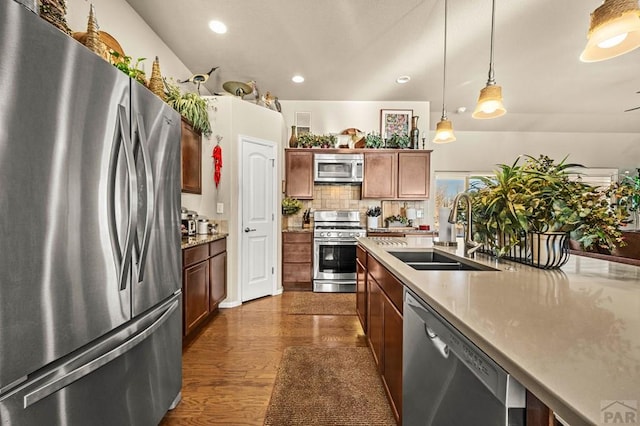 kitchen with dark wood-style flooring, recessed lighting, stainless steel appliances, pendant lighting, and a sink