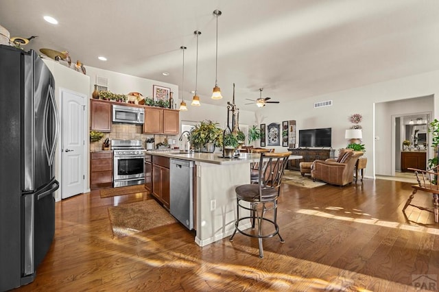 kitchen featuring dark wood-style flooring, open floor plan, visible vents, appliances with stainless steel finishes, and a sink