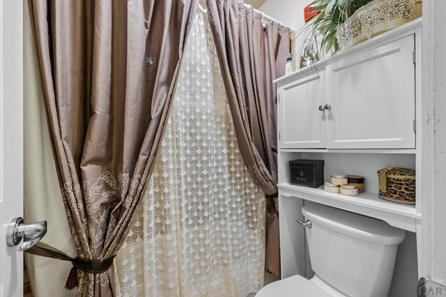 bathroom featuring toilet and a shower with shower curtain