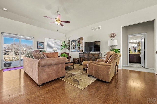 living area with hardwood / wood-style floors, ceiling fan, and visible vents