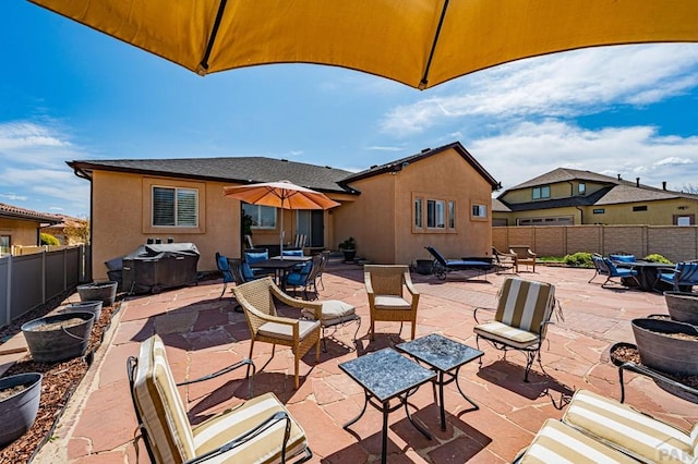 view of patio / terrace with outdoor dining space, a fenced backyard, and a grill